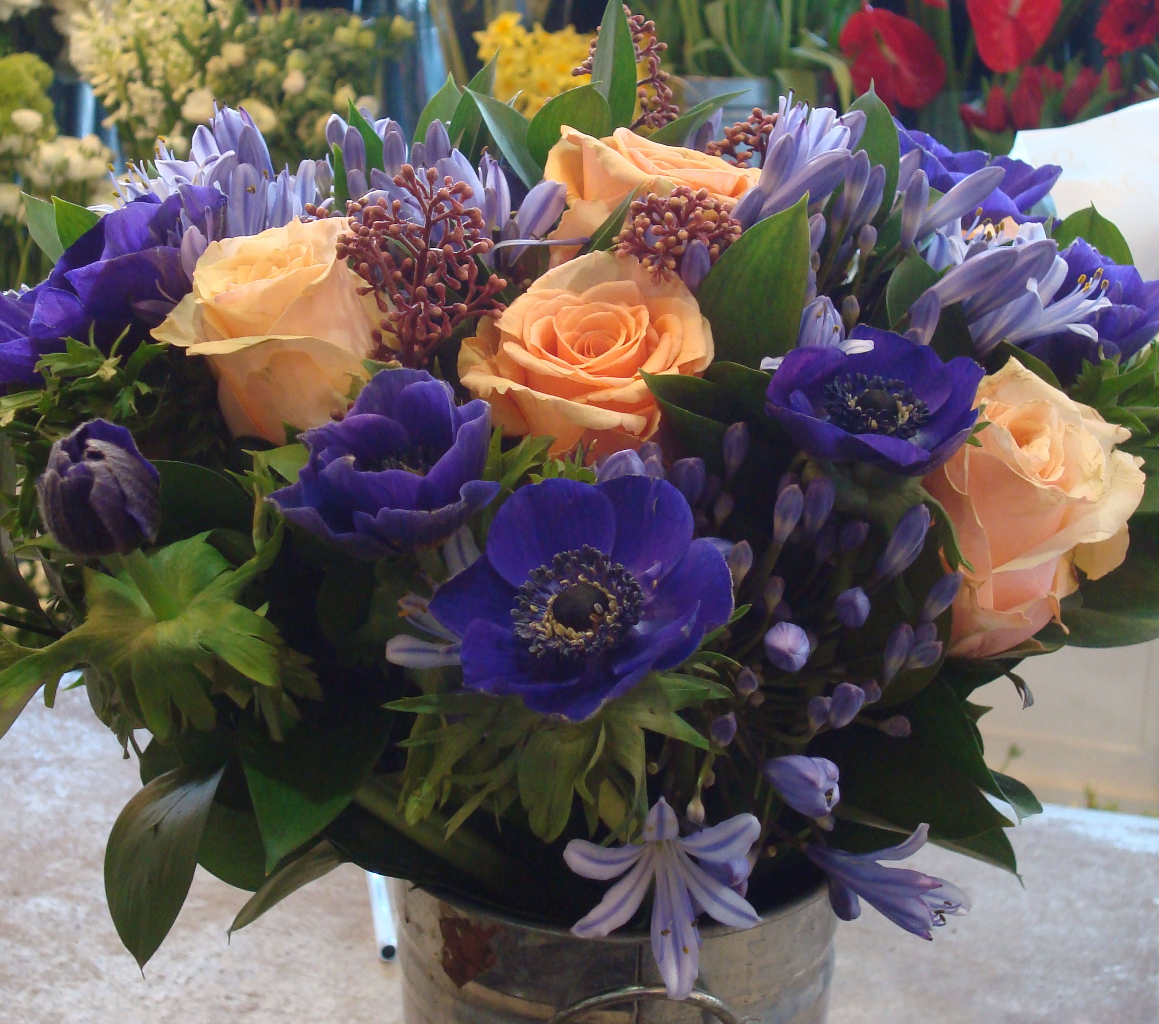 Complementary bouquet Blue Anemonmies and agapanthus + orange roses